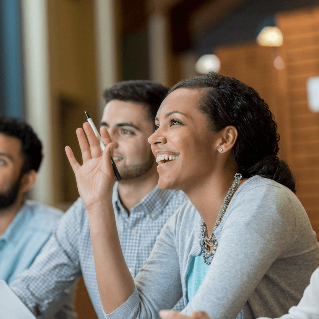 A woman in a meeting showing curiosity and enjoyment.